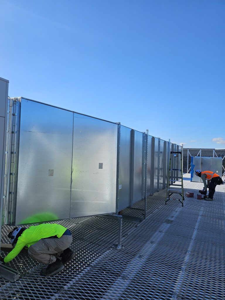 Ben Air technicians working on commercial HVAC duct installation on a rooftop in Auckland.